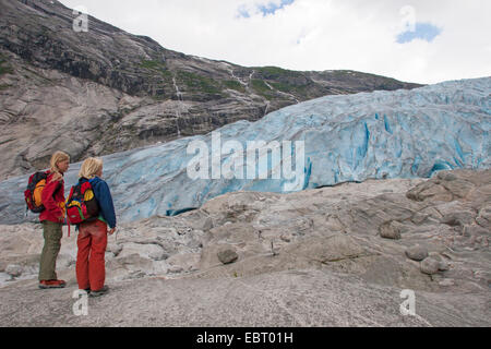 two children standing in front of Nigardsbreen glacier tongue , Norway, Jostedalsbreen National Park Stock Photo