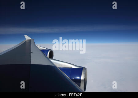 view through a wing of airplane Boeing 747 to the clouds and the sky Stock Photo