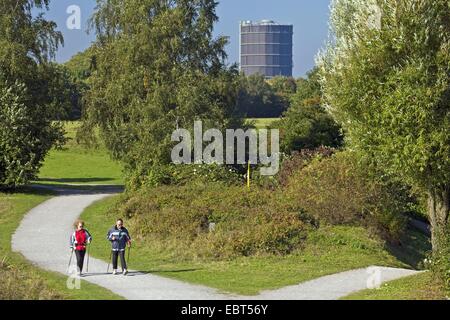 two Nordic walker in the tree and shrub garden Ripshorst, Gasometer Oberhausen in background, Germany, North Rhine-Westphalia, Ruhr Area, Oberhausen Stock Photo