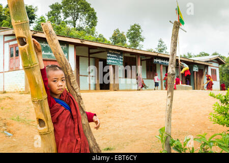 A young boy monk is standing outside his school building in Burma, Myanmar, South East Asia Stock Photo