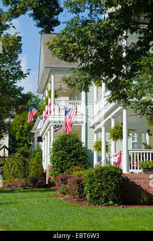 American Flags and buntings hang from a front porch of an upscale, Victorian style home in celebration of the upcoming holiday Stock Photo