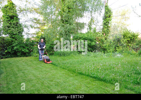 man mowing the lawn, Germany, Ruhr Area, Castrop-Rauxel Stock Photo
