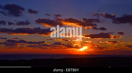 An impressive and colourful sunset over Paphos airport with an aeroplane coming in to land Stock Photo