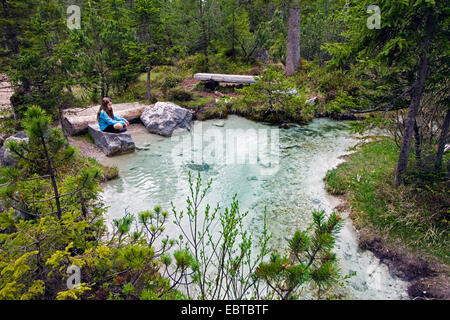 girl sitting on a rock at the origin of Isar river, Austria, Tyrol, Karwendel Mountains, Hinterautal Stock Photo