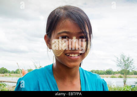 A Burmese girl with Thanaka paste on her face in the shape of a leaf Stock Photo