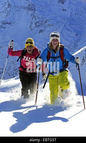 two teenage girls with snow shoes in snow, France, Savoie Stock Photo