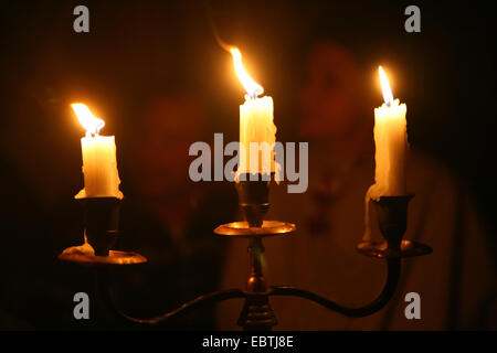 three burning candles in candleholder Stock Photo