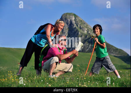 family walking in the Alps and looking at a map, France, Savoie Stock Photo