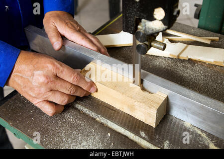 elderly carpenter working on a band saw in a joinery Stock Photo