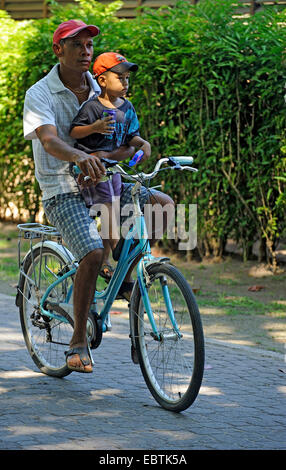 father and son cycling together, Seychelles Stock Photo
