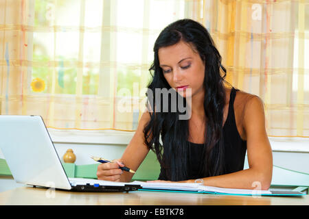 young student sitting at her desk with laptop and learning Stock Photo