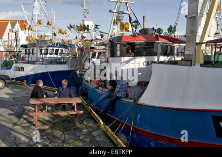 fishermen sitting by a trawler in harbour, Norway, Karmoy, Skudeneshavn Stock Photo