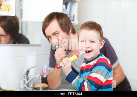 father and son brushing their teeth together Stock Photo