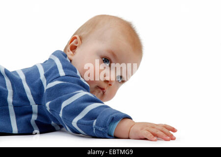 curious baby in romper lying on the ground Stock Photo