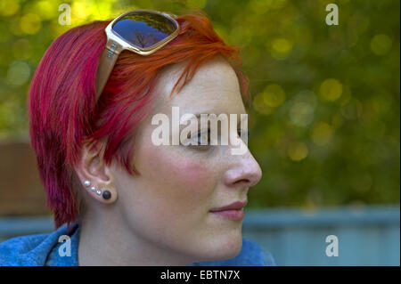 young redhaired woman with sunglasses looking serious Stock Photo