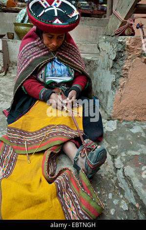 young woman in traditional dress working on a blanket at the local artisan workshop, Peru, Chincheros Stock Photo