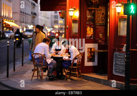 kitchen staff sitting at a table together in front of a restaurant at Marais, the jewish quarter, France, Village St. Paul, Paris Stock Photo