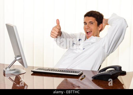 successful young manager sitting at a desk and smiles Stock Photo