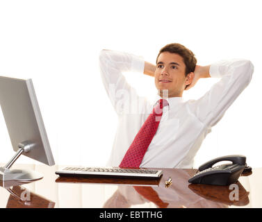 successful young manager sitting at a desk and smiles Stock Photo