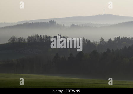 clearing morning mist over hilly landscape with forests and meadows, Germany, Saxony, Vogtland Stock Photo