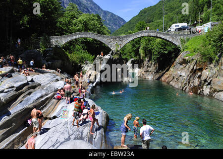 people bathing in Verzasca river at Ponte dei Salti at Lavertezzo, Switzerland, Ticino, Verzascatal Stock Photo