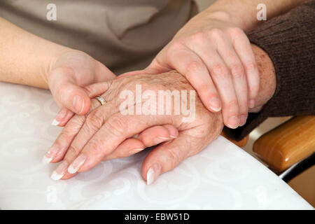 young woman comforting a widow after event of death, grief counseling Stock Photo