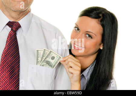 young woman squeeze money out of a man Stock Photo