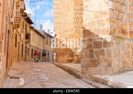 two pilgrims in the streets of Castrojeriz, Spain, Kastilien und Leon, Burgos, Castrojeriz Stock Photo