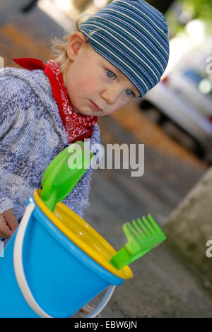 little boy with sand toys on the way to playground Stock Photo