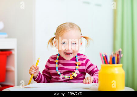 a little girl drawing with crayons Stock Photo