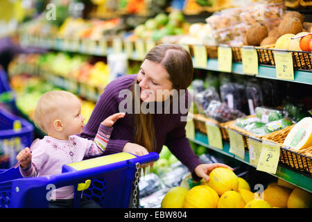 a young mother with baby shopping in a supermarket Stock Photo