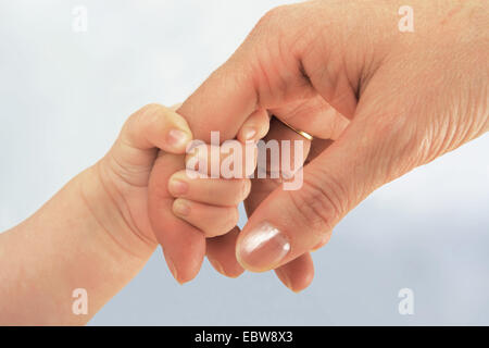 Baby grabbing mothers index finger Stock Photo