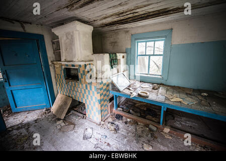 big stove with bedspace in old wooden cottage in abandoned Stechanka village, Chernobyl Exclusion Zone, Ukraine Stock Photo
