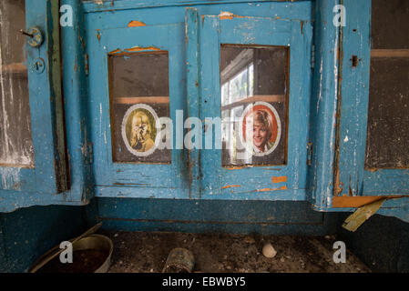 blue cupboard with women pictures in old wooden cottage in abandoned Stechanka village, Chernobyl Exclusion Zone, Ukraine Stock Photo