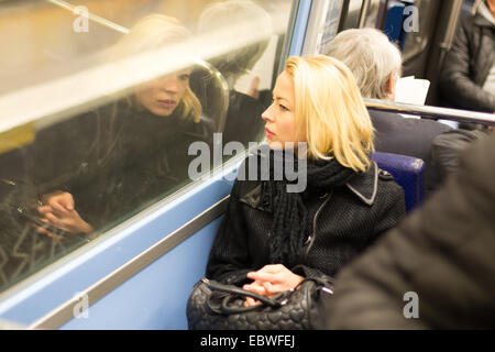 Woman looking out metro's window. Stock Photo