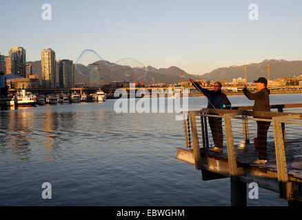 Man making giant soap bubbles, False Creek, Vancouver, British Columbia, Canada Stock Photo