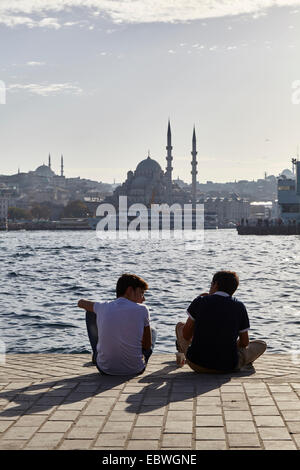 Boys talking on quayside in Istanbul Turkey Stock Photo