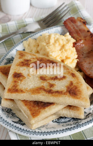 Irish potato farls or potato cakes with bacon and scrambled eggs Stock Photo