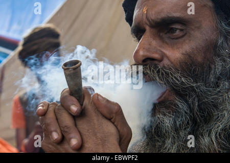 Udaisin Sadhu, holy man, smoking marihuana at the Sangam, the confluence of the rivers Ganges, Yamuna and Saraswati Stock Photo