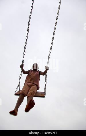 little girl swinging up in the air, Burundi, Bujumbura Stock Photo
