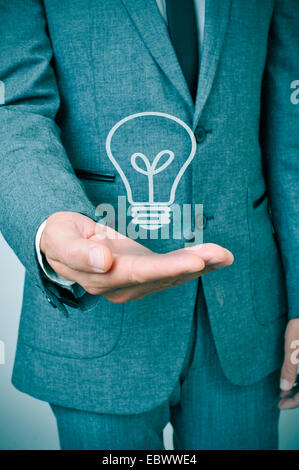 a man wearing a suit with a lightbulb drawn in his hand Stock Photo