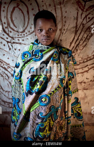 young woman staning in front of painted wall, Burundi, Karuzi, Buhiga Stock Photo