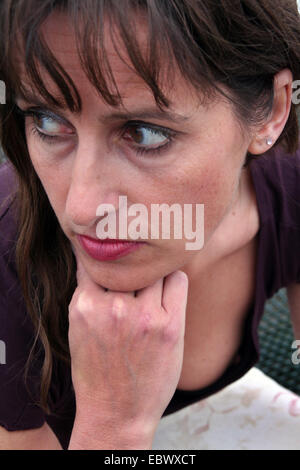 thoughtful middle-aged woman with head resting on her hand Stock Photo