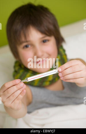 sick boy with clinical thermometer lying in bed Stock Photo
