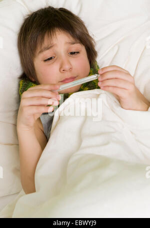 sick boy with fever in bed Stock Photo