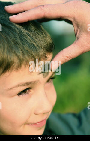 young boy being blessed by a priest who is putting ash colour onto his forehead with a thumb Stock Photo