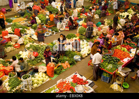 Local vendors in unusual birdseye angle from above with blurred movement in colorful printed clothes in fruit shopping center on market day, Guatemala, Chichicastenango Stock Photo