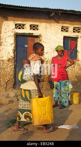 women at the poor area of the capital city taking water to their homes in canisters, baby is sleeping on its mother's back, Burundi, Bujumbura mairie, Buyenzi, Bujumbura Stock Photo