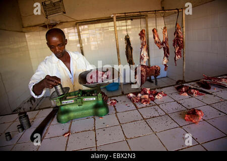 butcher weighing meat on a scale, Rwanda, Nyamirambo, Kigali Stock Photo