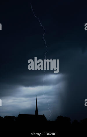Lightning bolt over church and sky filled with rain and storm clouds. Vadstena abbey, Sweden. Stock Photo